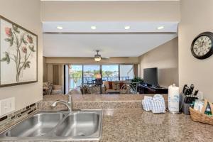 a kitchen with a sink and a living room at Midnight Cove II 134F in Siesta Key