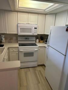 a kitchen with a white refrigerator and a microwave at Midnight Cove II 211F in Siesta Key
