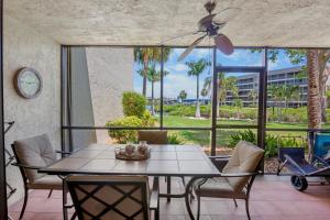 a dining room with a table and chairs and a large window at Midnight Cove II 213F in Siesta Key