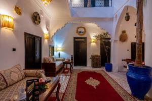 un soggiorno con divano e tappeto rosso di Riad des remparts Marrakech a Marrakech