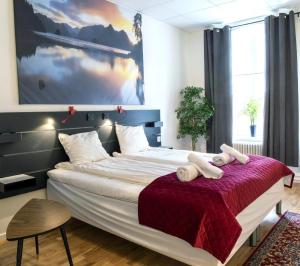 a bedroom with a large bed with two white towels at Beautiful Home In Karlshamn With Two Bedrooms And Wifi in Karlshamn
