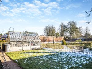 a greenhouse in a garden with snow on the grass at Peartree Cottage - Uk45496 in Great Budworth +7 photos