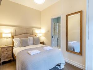 a bedroom with a large bed with a mirror at Peartree Cottage - Uk45496 in Great Budworth