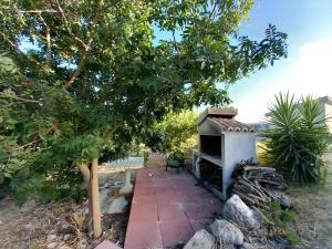 einen Garten mit einem Steingang und einem Backofen im Freien in der Unterkunft Domo Clelia in Nulvi