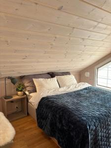 Un dormitorio con una cama y un techo de madera. en Magical Winter Days At Sjusjøen, en Mesnali