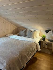 una cama en una habitación con techo de madera en Magical Winter Days At Sjusjøen, en Mesnali