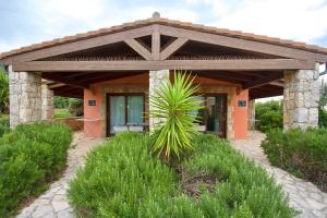 ein kleines Haus mit Holzdach in der Unterkunft Village surrounded by greenery with swimming pool just a few minutes from Alghero in Alghero