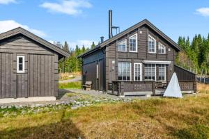 una gran casa de madera con un cobertizo en Magical Winter Days At Sjusjøen, en Mesnali