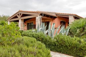 ein Haus mit Pflanzen davor in der Unterkunft Village surrounded by greenery with swimming pool just a few minutes from Alghero in Alghero