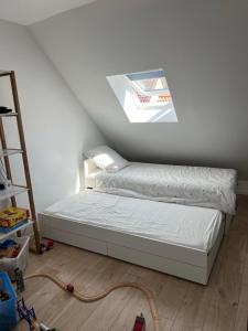 a bed in a room with a skylight at Maison idéale famille, 6 pers - Disney 15 min in Quincy-Voisins