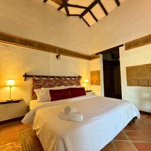 ein Schlafzimmer mit einem großen weißen Bett in einem Zimmer in der Unterkunft Hacienda Cascanueces in Villa de Leyva