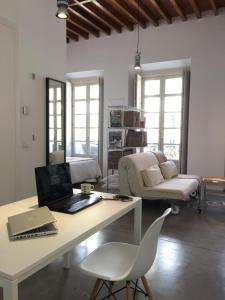sala de estar con escritorio y ordenador portátil. en Suncity Ismo Arquitectura, en Málaga