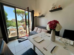 une table blanche avec un vase de fleurs dessus dans l'établissement Mais 3 pièces 6 couchages SAINT CYPRIEN SC010-013, à Saint Cyprien Plage