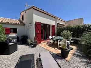 d'une terrasse avec une table et une porte rouge. dans l'établissement Mais 3 pièces 6 couchages SAINT CYPRIEN SC010-013, à Saint Cyprien Plage 18 autres photos