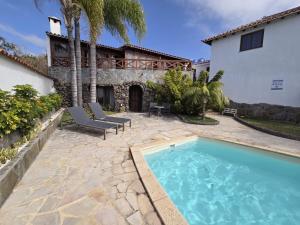 a backyard with a swimming pool and a house at Gardel Esencia in Icod de los Vinos