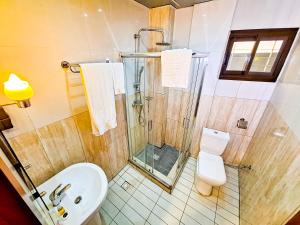 a bathroom with a shower and a toilet and a sink at Belmann Bonapriso in Douala