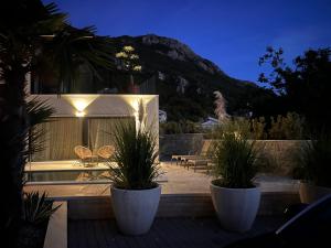 a house with potted plants on a patio at night at Vila panorama in Cetinje