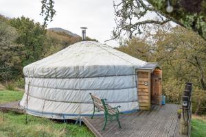 Jurte mit einer Bank auf einer Holzterrasse in der Unterkunft Finest Retreats - Pandy Traditional Yurt in Penmaen Pool
