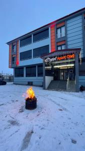 a fire in front of a building in the snow at Ögel Apart Otel in Sarıkamıs