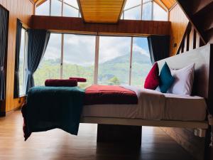 努沃勒埃利耶皮金斯奈斯特酒店的一间带床的卧室,配有大窗户