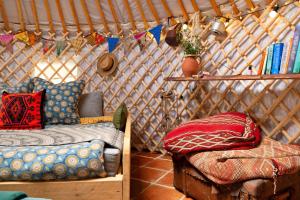 ein Zimmer mit einem Bett und einer Couch in einer Jurte in der Unterkunft Finest Retreats - Pandy Mongolian Yurt in Penmaen Pool + 11 Fotos