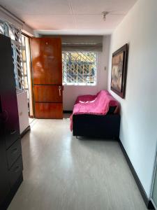 a bedroom with a bed and a window and a door at casas bosque apartaestudio in Bogotá