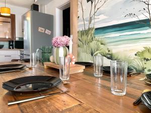 een eettafel met borden en glazen erop bij L'Echappée Salée - Close to center - Cozy in Longeville-sur-Mer