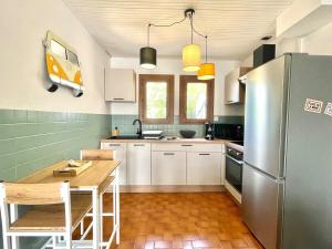 een keuken met een houten tafel en een roestvrijstalen koelkast bij L'Echappée Salée - Close to center - Cozy in Longeville-sur-Mer