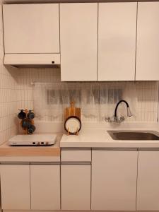 een keuken met witte kasten en een spoelbak bij Stay comma in Seoul