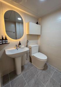 een badkamer met een toilet, een wastafel en een spiegel bij Stay comma in Seoul
