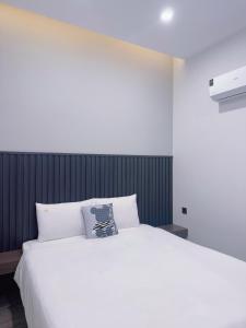 a bedroom with a white bed with a black headboard at Lin Hotel and Coffee in Hòa Bình