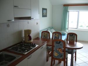 a kitchen with a counter and a table with chairs at Apartmani Marija in Primošten