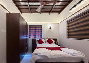 une chambre avec un grand lit avec des oreillers rouges dans l'établissement Mangrove Heritage Home, Chendamangalam, à Cochin 12 autres photos