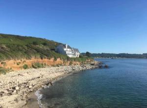 ein Haus am Ufer eines Gewässers in der Unterkunft Logement exceptionnel, sur plage in Trélévern