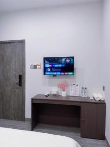 a room with a desk with a tv on the wall at Lin Hotel and Coffee in Hòa Bình +5 photos