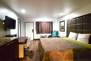 a hotel room with a bed and a desk at Century Motel Buena Park Anaheim CA 91 in Buena Park