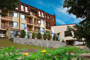 a hotel with flags in front of a building at Хотел Кипарис, Враца in Vratsa