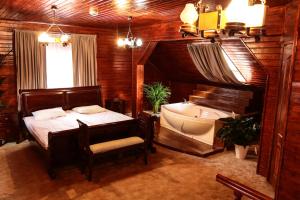 a bedroom with a tub and a bed and a bed and a chair at Hotel Apollonia in Braşov
