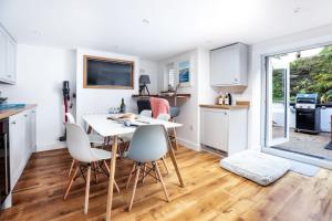 eine Küche und ein Esszimmer mit Tisch und Stühlen in der Unterkunft Wavecrest in Portreath