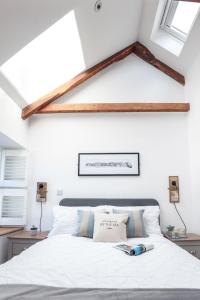 1 Schlafzimmer mit einem weißen Bett und 2 Fenstern in der Unterkunft Wavecrest in Portreath