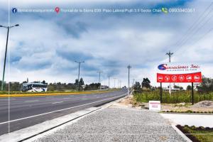 an empty highway with a bus on the road at Motel Sensaciones in Latacunga