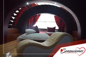 a room with a bed and a chair in a tunnel at Motel Sensaciones in Latacunga