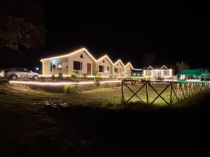 a row of houses with lights in the night at The Hideaway Chail in Chail