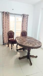 a table and two chairs in a room at Elite Home Stay in Raipur
