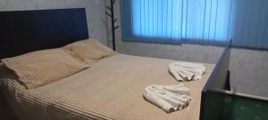 a bed with two towels on it with a window at Mary&George in Sectorul Botanica