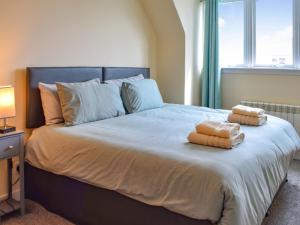ein Schlafzimmer mit einem großen Bett mit zwei Handtüchern darauf in der Unterkunft Burnside Cottage in Bruichladdich