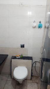 a bathroom with a white toilet in a room at Elite Home Stay in Raipur