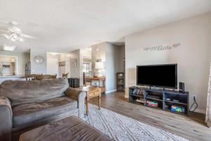 ブランソンにあるPoolside Oasis at the Pointe - 2BR Condo Minutes From Table Rock Lakeのソファと薄型テレビのあるリビングルーム