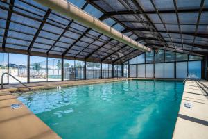 ブランソンにあるPoolside Oasis at the Pointe - 2BR Condo Minutes From Table Rock Lakeの青い水と窓のあるスイミングプール