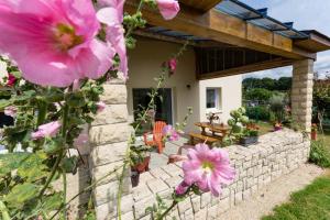 een huis met een stenen muur en roze bloemen bij Les hortensias in Grâces